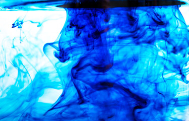 Blue ink spilled into water and photographed in motion