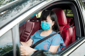 Woman in protective mask driving  car on the  road