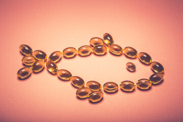 Cod liver oil capsules in a fish shape with copy space. Healthcare concept
