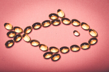 Cod liver oil capsules in a fish shape with copy space. Healthcare concept