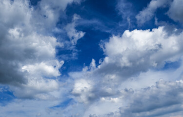 White fluffy clouds in the blue azure sky. Summer good weather background.