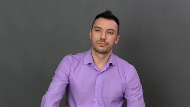 Focused young man close-up. He shows emotions professionally. Soft light. High-quality footage FullHD.