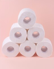 White toilet paper rolls on pink background. Hygiene concept.