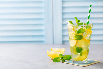 Lemonade, lemon ice tea, mint cocktail in glass. Blue background. Close up. Copy space. © annapustynnikova