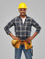 profession, construction and building - happy smiling indian worker or builder in helmet with tool belt over grey background