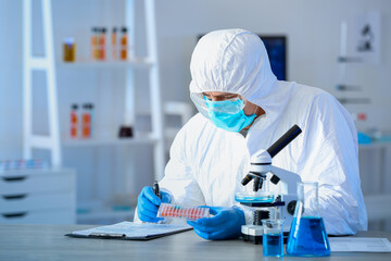 Scientist working with microscope in laboratory