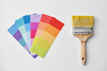 repair, renovation and painting concept - paint brush and color palette on white background