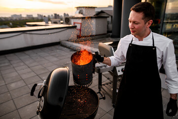 male chef holds special device for igniting the grill.