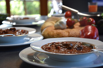 spicy hungarian stew with beef tomatoes, paprika, onions and garlic on white plate served for lunch oder dinner - healthy meal