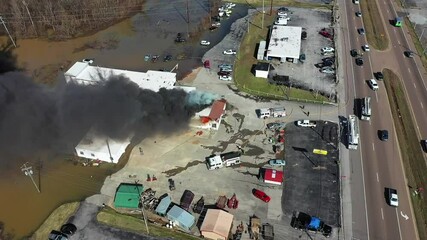 Ascending drone view of an active fire with multiple agencies in attendance including local fire and police