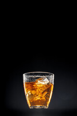Glass of whisky on black background, copy space