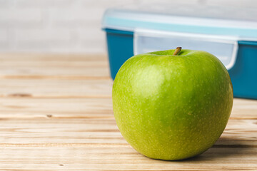 Green apple on wooden table, close up