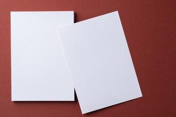 Blank white business cards on burgundy paper background