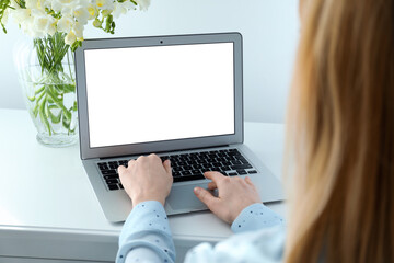 Woman working on modern laptop at white table indoors, closeup