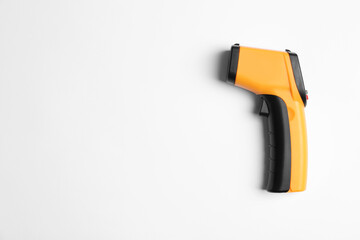 Modern non-contact infrared thermometer on white background, top view. Space for text