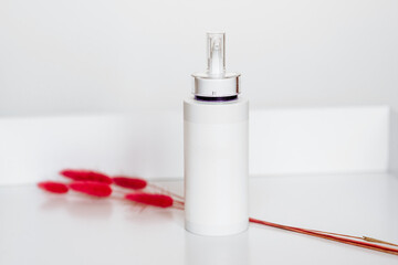 White bottle for cosmetics with the batcher