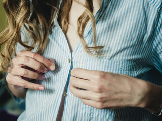 girl buttons on a blouse close-up