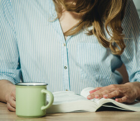 Obraz premium girl reading a book at the table close-up