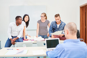 Obraz premium Dozent am Laptop Computer und Studenten Team