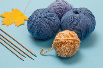 Woolen yarn for knitting. Balls of natural wool yarn and knitting needles