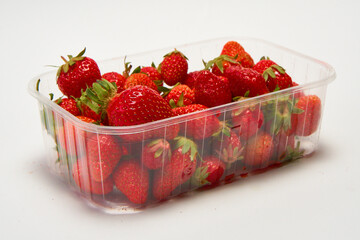 Tray of ripe red strawberries on a white background.