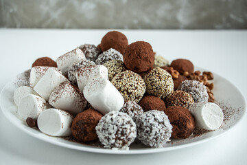 a lot of delicious chocolate truffles, rolled in cocoa, coconut, sesame with marshmallows and nuts, delicious and beautiful dessert