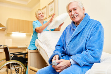 Senior man is sitting on his nursing bed