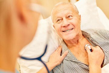 Senior is being listened to with the stethoscope