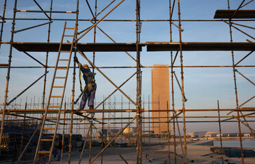 BAHRIAN BAY, BAHRAIN - FEBRUARY 05: The technician working on the top of scaffold jacks platform for construction of Grandstand near water front at Bahrain Bay on February 05, 2018.