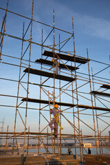 BAHRIAN BAY, BAHRAIN - FEBRUARY 05: The technician working on the top of scaffold jacks platform for construction of Grandstand near water front at Bahrain Bay on February 05, 2018.