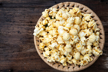 Popcorn placed on a plate on old wood.