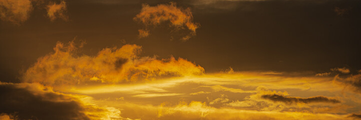 Panorama dramatic clouds illuminated rising of sun floating in sky to change weather. Soft focus, motion blur sky majestic meteorology cloudscape.