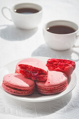 Macaroons and coffee cup on white wood table.