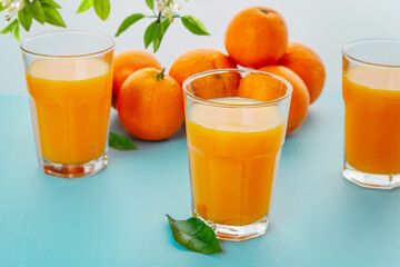 Healthy drink. Fresh Orange juice in the glass. Fresh fruits and leaves.