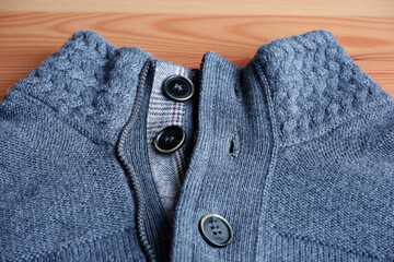 Woolen fabric with buttons on a wooden background