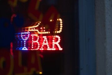 Colorful bright lit sign of a bar at night
