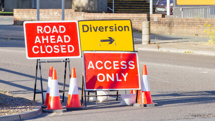 Red and Yellow Road Signs Indicating a Road Closure and Diversion
