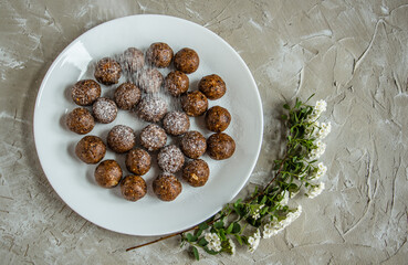 a lot of delicious truffles from dried fruits, sprinkled with powdered sugar, tasty, healthy and beautiful dessert