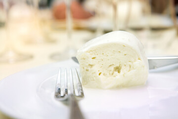 buffalo mozzarella cheese from Campania region Italy on a laid table  while he is eating it on a plate
