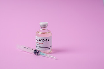 Coronavirus vaccination glass bottle on a pink background Covid-19 Vaccination Equipment Research on the concept of pandemic influenza vaccines around the world.