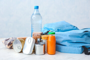 Schoolbag with different products on light background. Concept of Backpack Food Program