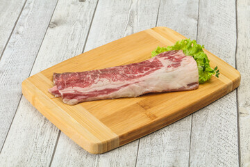 Raw beef bacon over wooden board