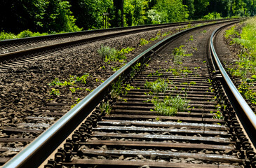 Obraz premium Schienen Gleise Eisenbahn Bahnstrecke Kurve Deutschland grün Unkraut Vegetation Natur Bäume Schwellen Railway Tracks Curve Germany Bogen parallel Zukunft Perspektive Infrastruktur Lennetal Werdohl
