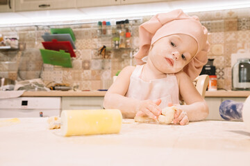 Little girl cooks at home in the kitchen