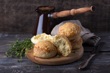 Homemade freshly baked scones with cheese and herbs, turk coffee on wooden board on wooden table. Traditional english buns	