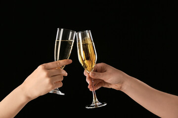 Female hands with glasses of champagne on dark background © Pixel-Shot