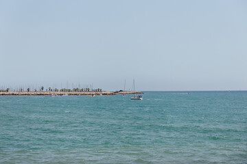 Yachts in sea near pier with blue sky at background in Catalonia, Spain