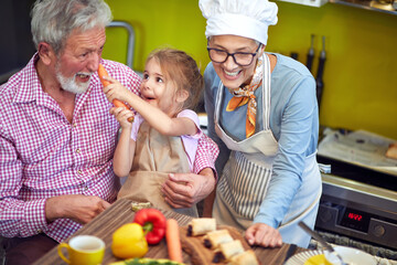 Cheerful   granddaughter at home prepare breakfast  with her  grandparents.