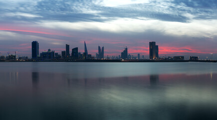 Fototapeta na wymiar Bahrain skyline and dramatic clouds during sunset and reflection on water