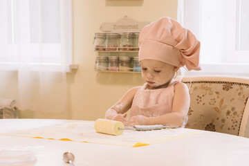 Little girl cooks at home in the kitchen